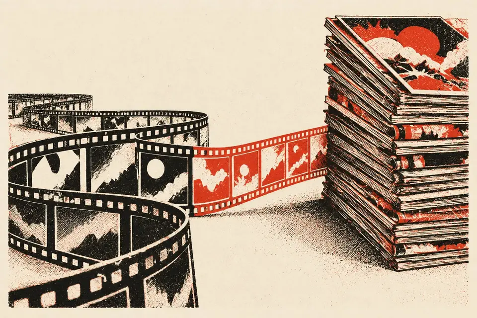 A long strip of film catching up with a tall stack of comic books, with one stretch of the film printed in red.